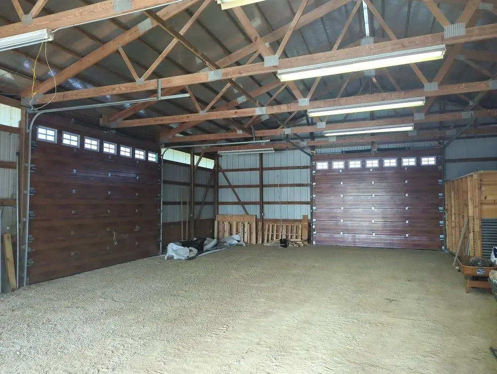 Two large sectional doors seen from inside a metal building