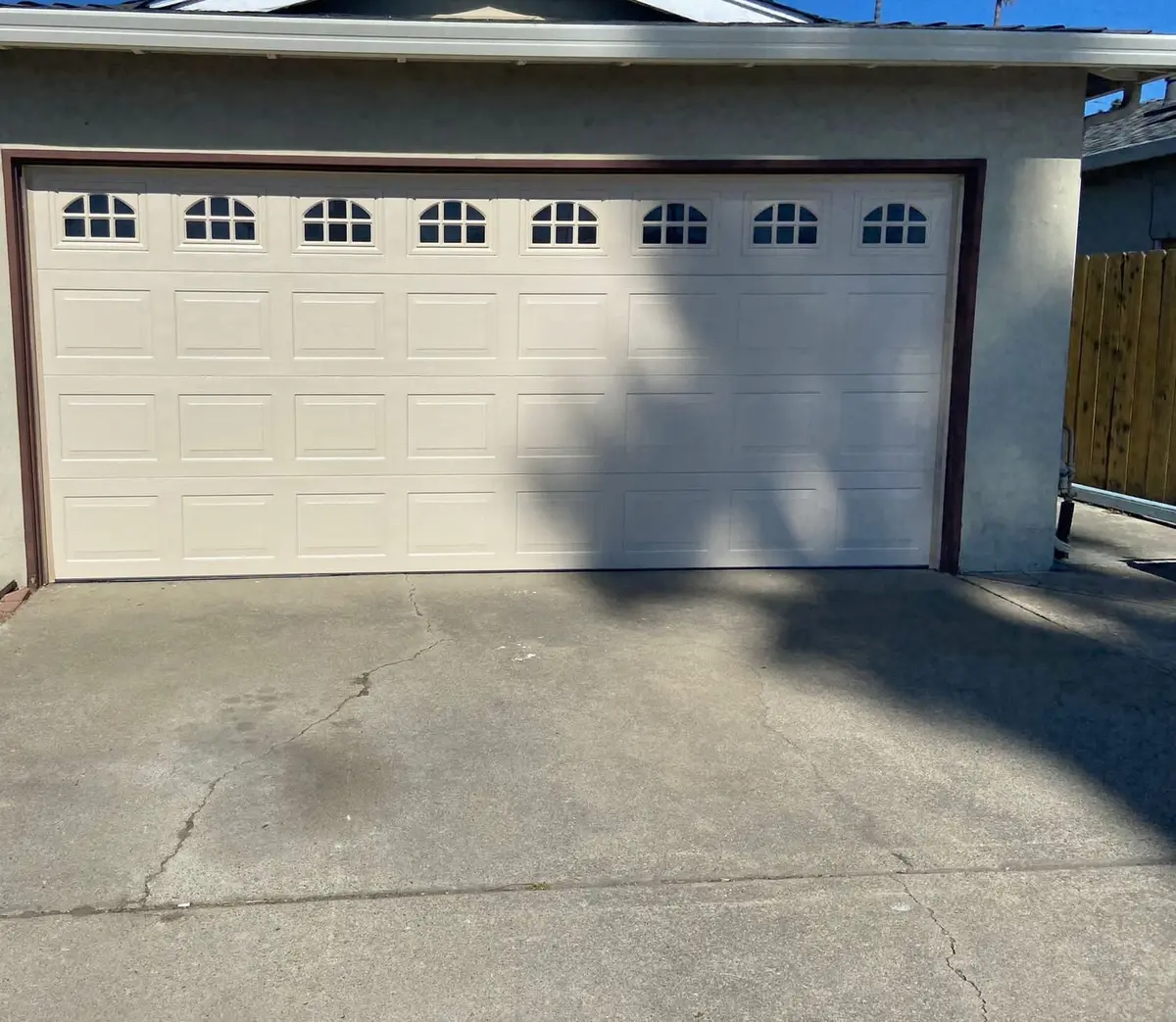 Cream raised panel garage door with arched windows