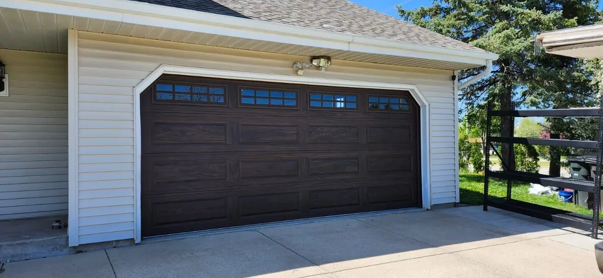Dark brown long panel garage door with a row of windows