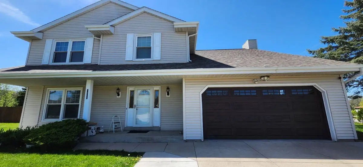Dark brown garage door with windows on a two story home