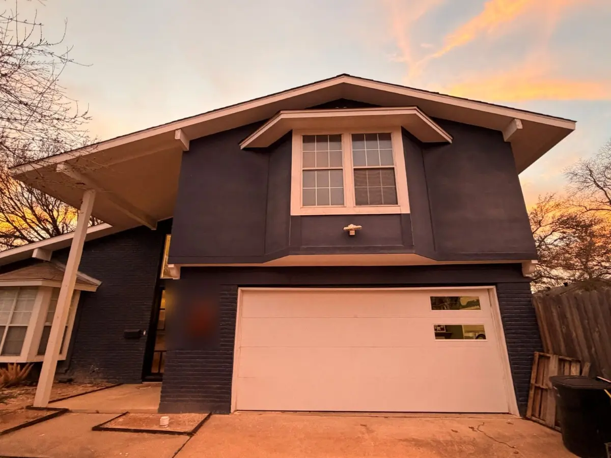 After: white flush modern garage door with offset windows installed by Tier One in Austin 78752, at sunset