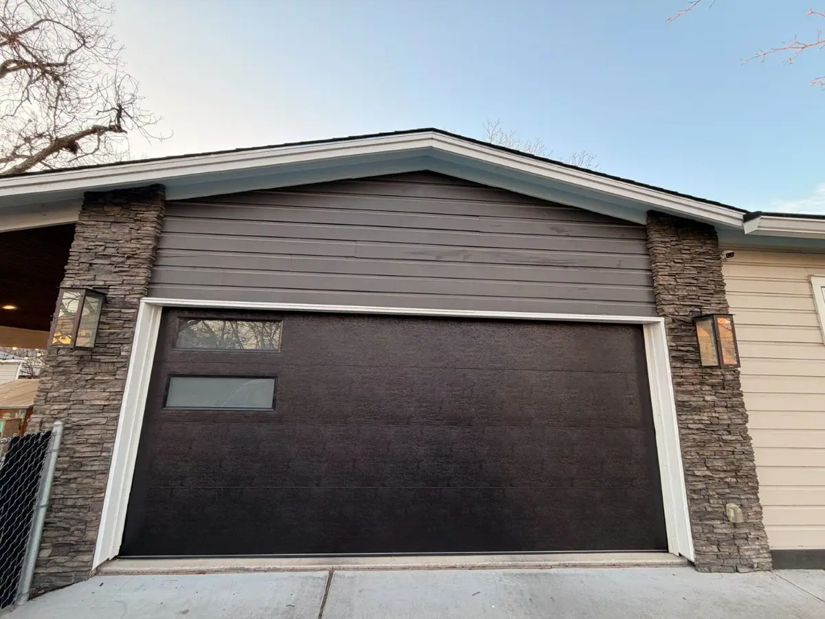 Dark textured modern garage door with side windows on a new home in Crestview, Austin, installed by Tier One
