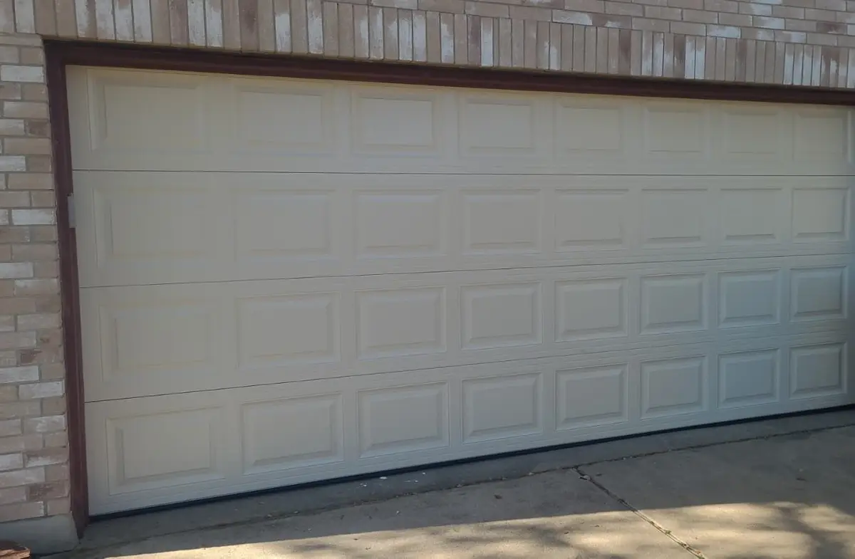 Almond short panel double garage door after all four panels were replaced by Tier One in Pflugerville