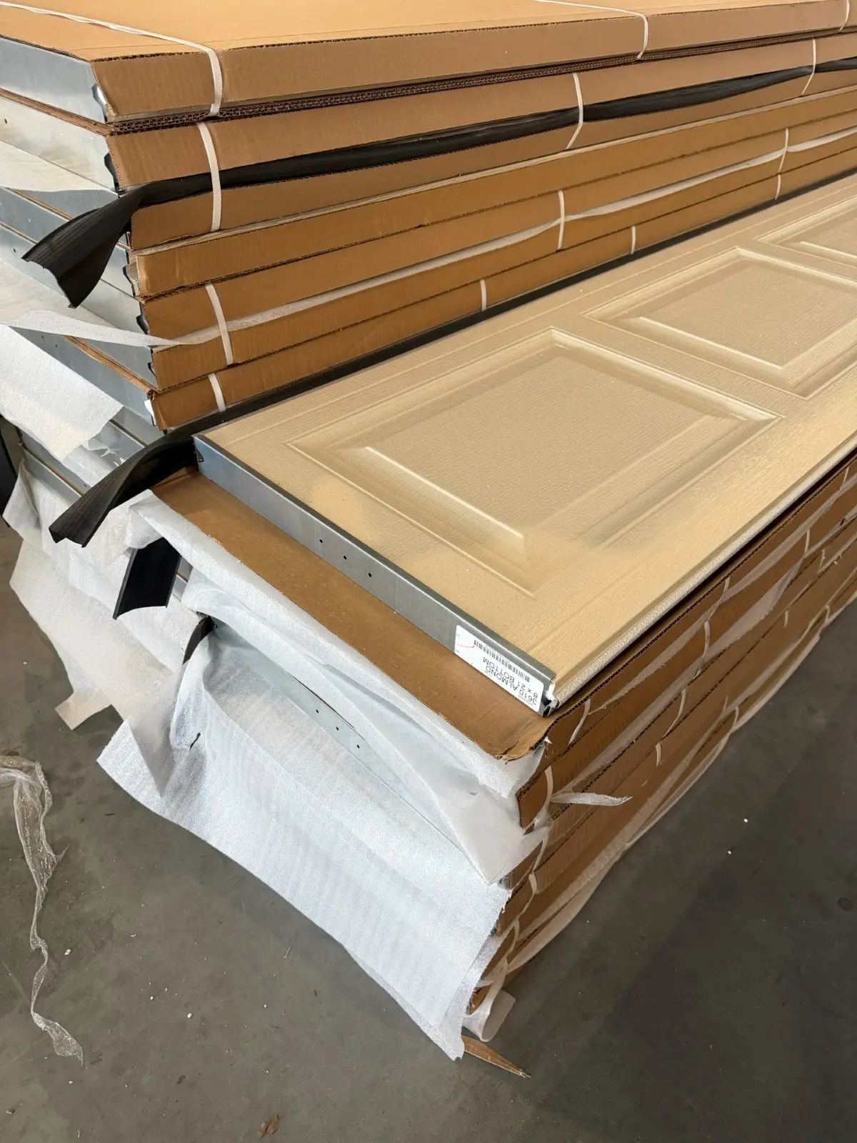 New garage door sections stacked and wrapped before installation
