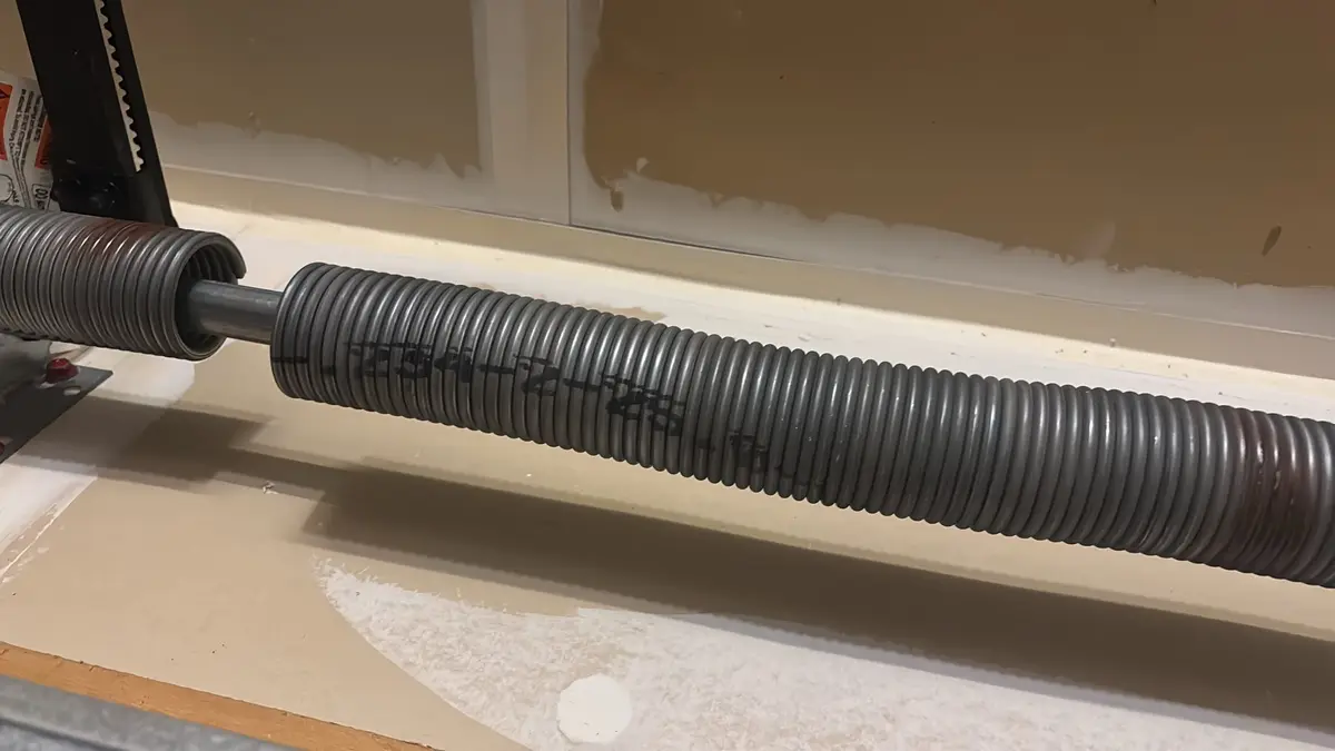 Broken torsion spring showing a clear gap in the coil above a garage door