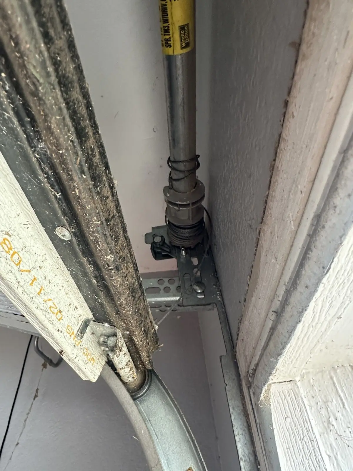 Loose garage door cable bunched at the drum at the end of the spring shaft