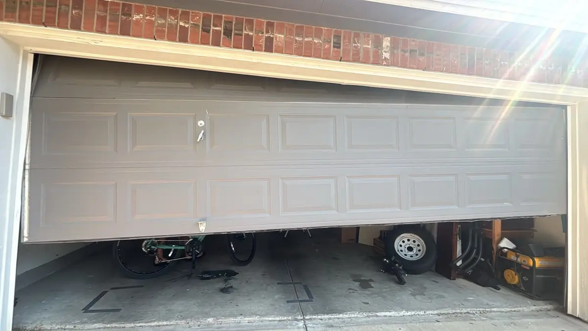 Garage door stuck partly open and out of level, before repair by Tier One