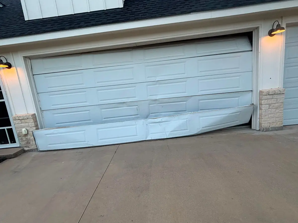 Garage door with damaged bottom panels before repair