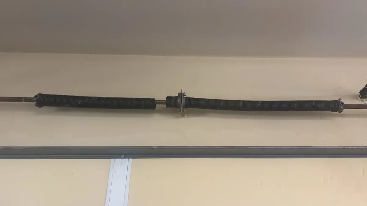 Pair of torsion springs on the shaft above a garage door
