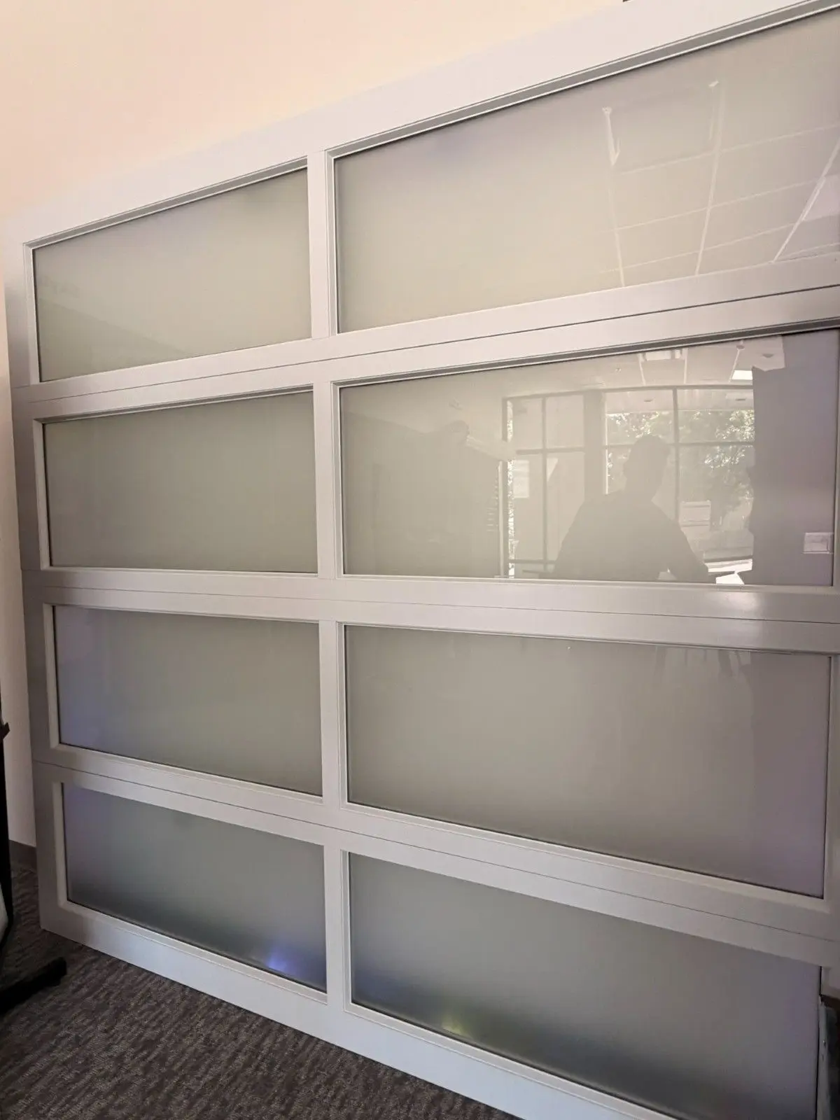 Showroom sample of a full view garage door with frosted glass panels
